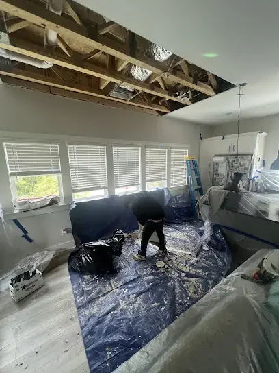 Ceiling opened above plastic-covered furniture while the room dries
